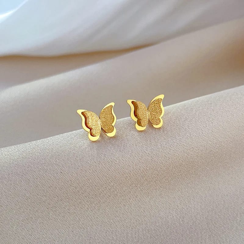 Aretes en forma de mariposa con tonos cafés y dorados