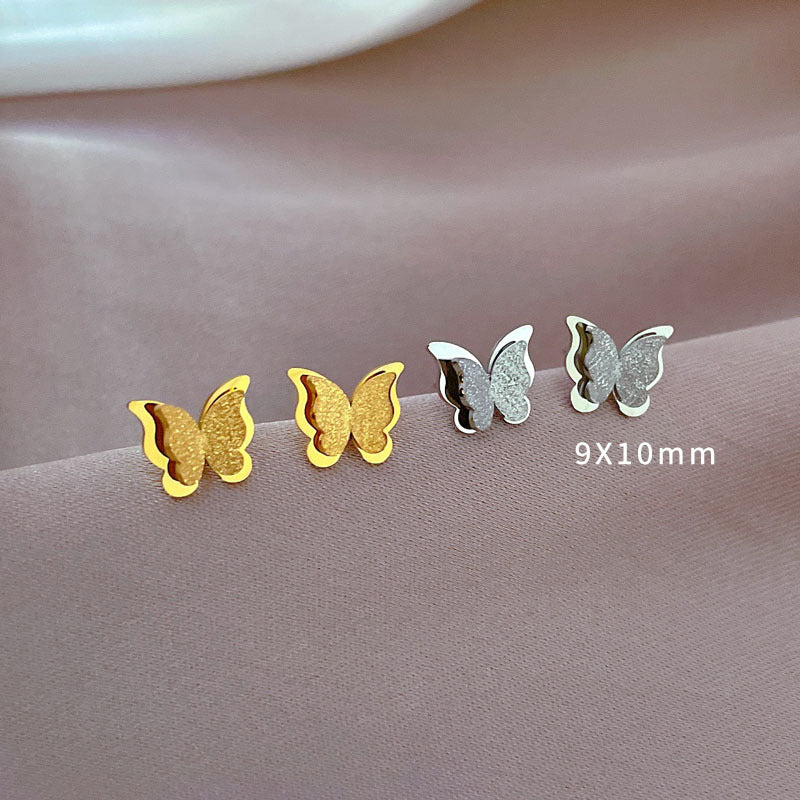 Aretes en forma de mariposa con tonos cafés y dorados